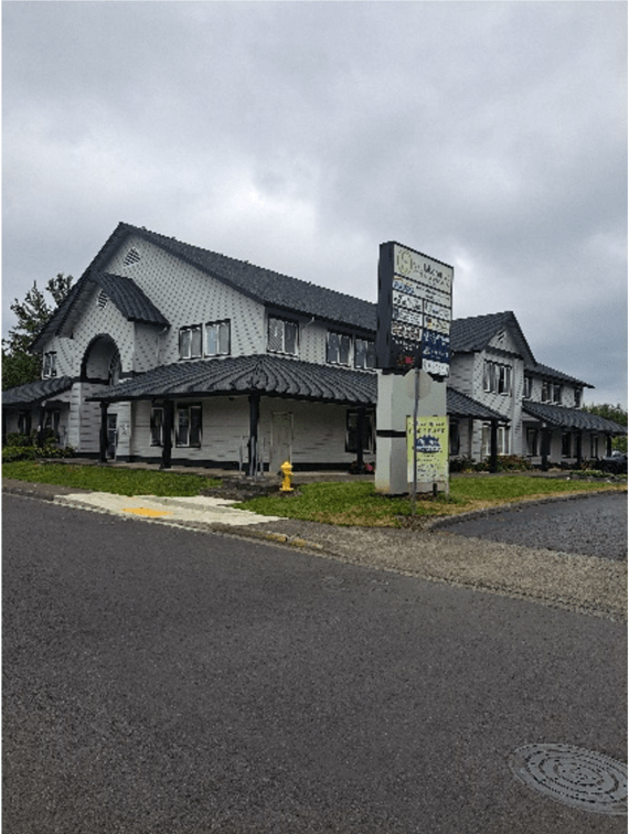 White Building Next To A Crossing Road